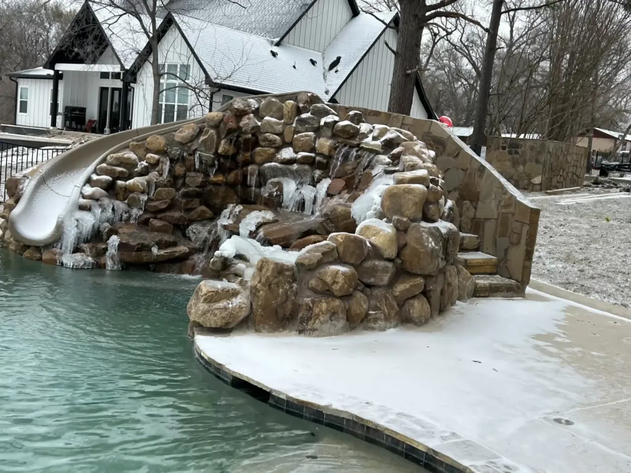 Boulder waterfall and slide iced over in a Texas winter, water still running